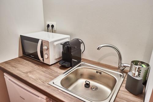 a kitchen counter with a sink and a microwave at Lycabettus View in Athens