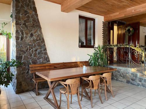 Une table et des chaises en bois sont disponibles sur la terrasse. dans l'établissement Viktoria Hotel, à Obroshino