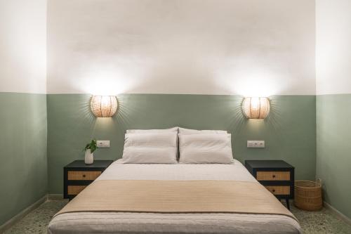 una camera da letto con un letto con due luci sul muro di Stellas Village House a Myrtia