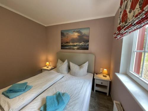 a bedroom with a bed with two towels on it at Ferienhaus Eichelhäher in Zossen