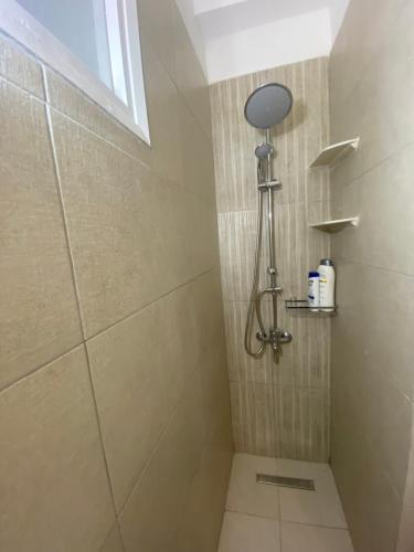 La salle de bains est pourvue d'une douche avec une porte en verre. dans l'établissement Domna Home Next To Sigrou Avenue, à Athènes