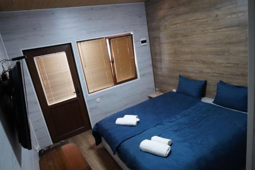 een slaapkamer met een blauw bed met 2 handdoeken erop bij Вилно селище "Свети Никола" - язовир Огоста, Монтана - рибари, приятели, гости 0988 продължи 70продължи 9990 in Montana