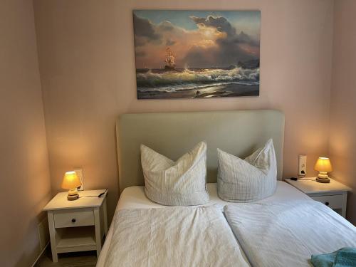 a bedroom with a white bed with two nightstands and two lamps at Ferienhaus Eichelhäher in Zossen
