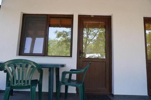 two chairs and a table in front of a house at Вилно селище "Свети Никола" - язовир Огоста, Монтана - рибари, приятели, гости 0988 продължи 70продължи 9990 in Montana