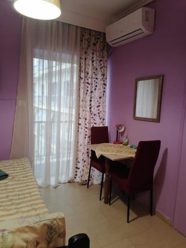 テッサロニキにあるAriadni Apartmentのテーブルと椅子、窓が備わる客室です。