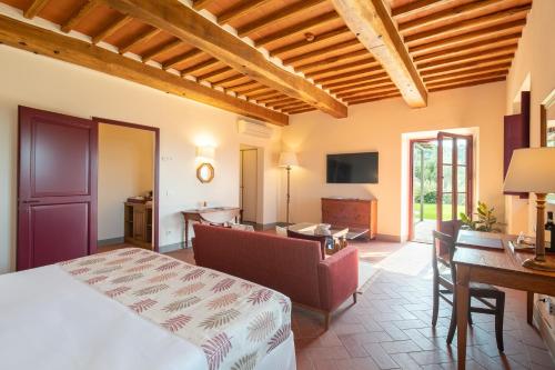 a bedroom with a bed and a desk and a couch at The Club House in Castelnuovo Berardenga