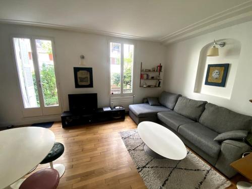 - un salon avec un canapé et une table dans l'établissement Tour Eiffel - Appartement avec jardin, à Paris