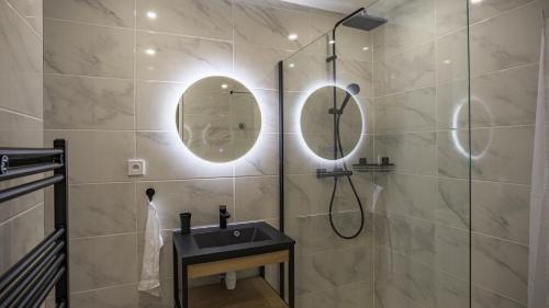 ein Bad mit einer Dusche, einem Waschbecken und Spiegeln in der Unterkunft Coeur de Bar - Pour Un Séjour Pétillant in Bar-sur-Aube
