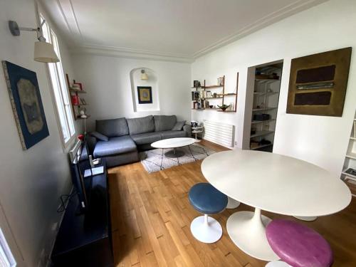 un salon avec une table blanche et un canapé dans l'établissement Tour Eiffel - Appartement avec jardin, à Paris