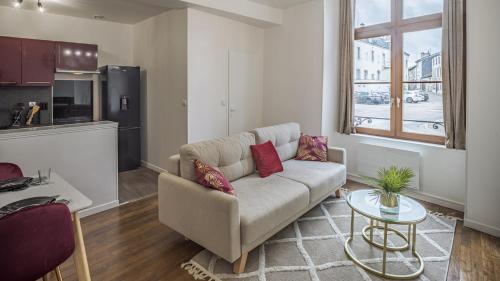 un salon avec un canapé et une table dans l'établissement Coeur de Bar - Pour Un Séjour Pétillant, à Bar-sur-Aube