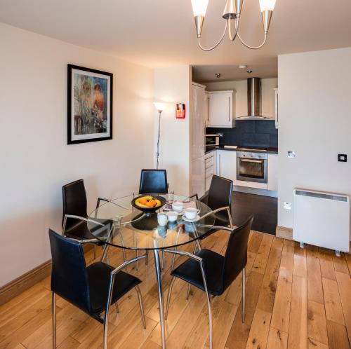 a dining room with a glass table and chairs at Fitzwilliam Point in Dublin