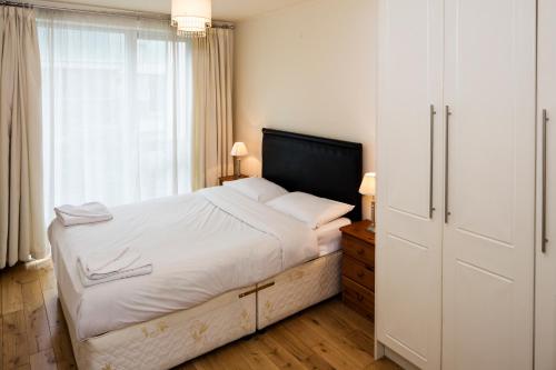 Un dormitorio con una cama grande y una ventana en Fitzwilliam Point, en Dublín