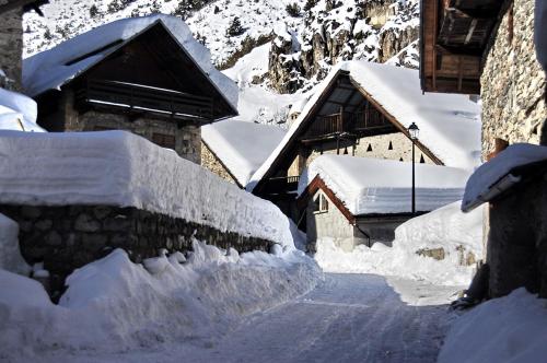 a group of snow covered houses on a street at MAISON CARAIL Névache 14 personnes in Névache