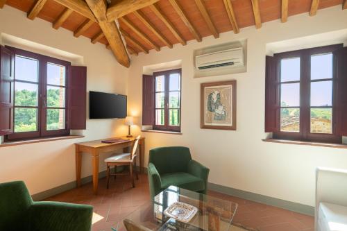 a living room with a desk and chairs and windows at The Club House in Castelnuovo Berardenga