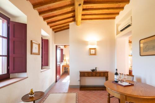 a living room with a wooden table and a dining room at The Club House in Castelnuovo Berardenga