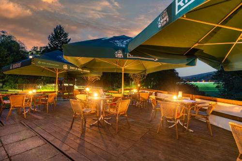 a patio with tables and chairs and umbrellas at Penzion U Hráze in Luhačovice