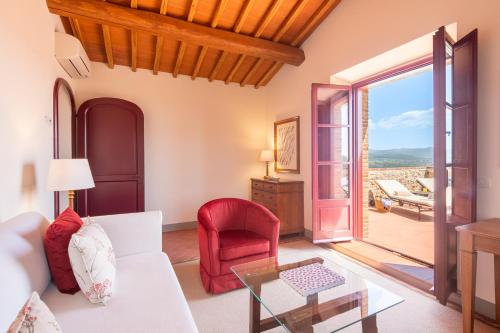 a living room with a white couch and a glass table at The Club House in Castelnuovo Berardenga