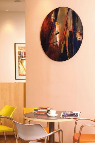 a table and chairs in a room with a painting on the wall at JW Marriott Mumbai Juhu in Mumbai