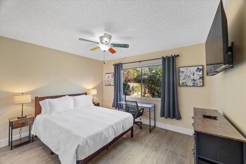 a bedroom with a bed with a ceiling fan and a desk at Beautiful home with spa and golf in Las Vegas