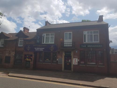 un edificio de ladrillo en una calle con una tienda en The Broadway Rooms, en Leicester