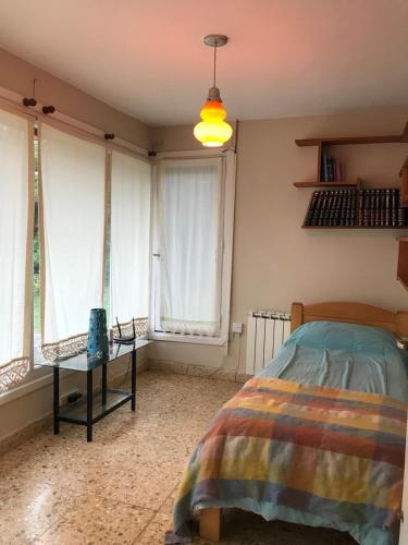 1 dormitorio con 1 cama y 2 ventanas en CHALET MOTTER en Villa Gesell