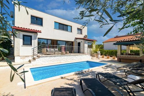 a villa with a swimming pool and a house at Villa Lelaina near Pula with private Pool and 3 km from the beach in Šegotići