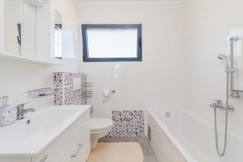 a white bathroom with a toilet and a sink at Villa Lelaina near Pula with private Pool and 3 km from the beach in Šegotići
