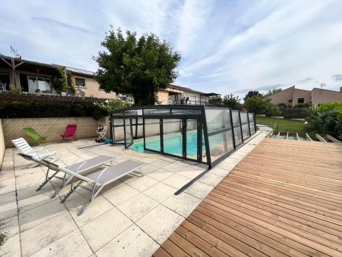 una piscina en una casa de cristal en un patio en Nid d'amour en Auvergne avec piscine en Le Broc