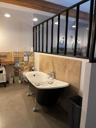 La grande salle de bains est pourvue d'une baignoire et d'une fenêtre. dans l'établissement Lou Luberon, à Ménerbes