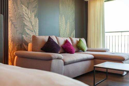 a living room with a couch with pillows on it at Panorama Resort & Spa in Feusisberg