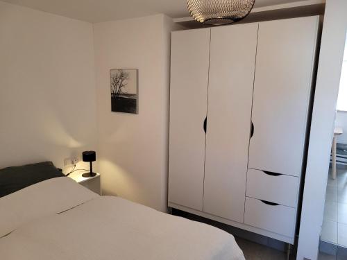 a bedroom with a white cabinet and a bed at Appartement am Stadtmuseum - ruhig und zentral gelegen in Bad Saulgau