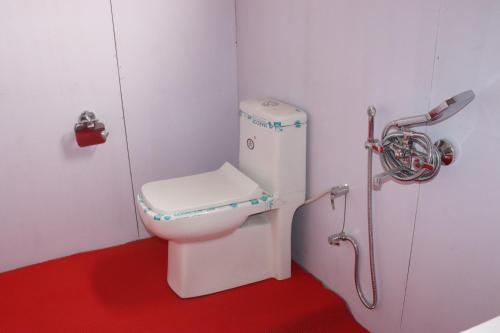 a small bathroom with a toilet with a shower at The hidden heaven cottage pangong merak in Meruk