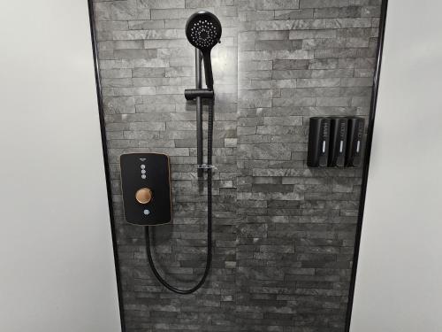 een douche met een douchekop in een bakstenen muur bij Rectory Roost in Spalding