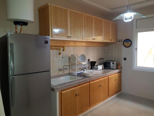 eine Küche mit Kühlschrank und Spüle in der Unterkunft Appart-ines l'Oasis du confort et luxe in Oujda