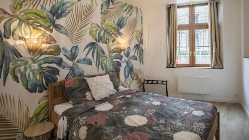 ein Schlafzimmer mit einem Bett mit einer tropischen Tapete in der Unterkunft Coeur de Bar - Pour Un Séjour Pétillant in Bar-sur-Aube