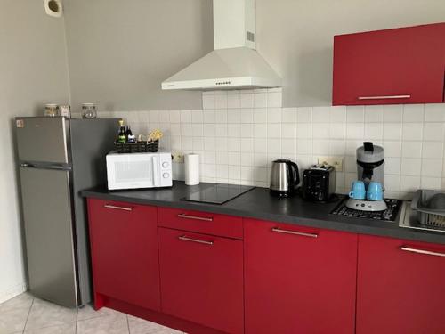 a kitchen with red cabinets and a silver refrigerator at Le 32 in Cognac