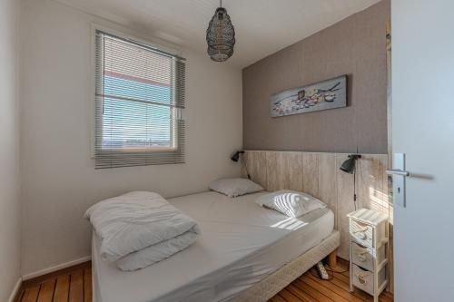 Un dormitorio pequeño con una cama y una ventana. en T2 Vue Mer Arcachon, en Arcachon