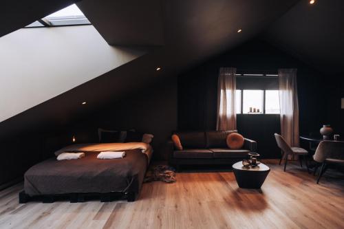 een slaapkamer met een bed, een bank en een tafel bij Keflavik Cozy Apartments in Keflavík