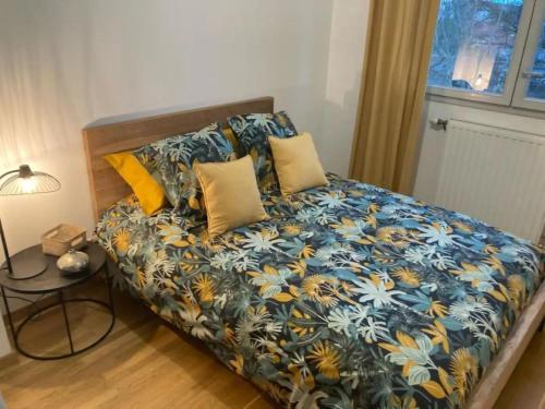 - une chambre avec un lit doté d'oreillers bleus et jaunes dans l'établissement Standing 3 Chambres, parkings, Terrasse, à Meyzieu