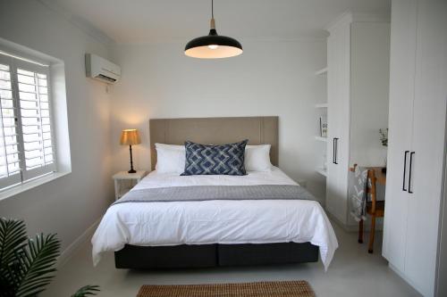 1 dormitorio con cama grande y almohada azul en 5 Sun Centre, en Plettenberg Bay
