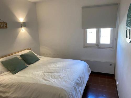 1 dormitorio con cama blanca y ventana en Costa Brava Beach House, en Begur