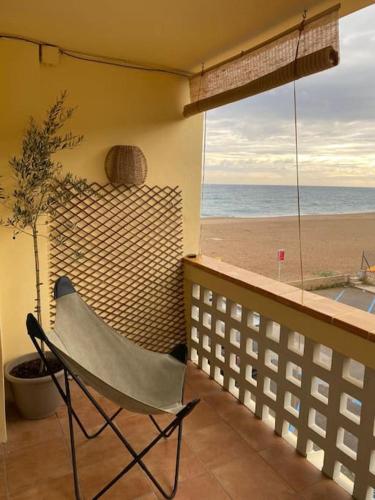 una silla en el balcón con vistas a la playa en Costa Brava Beach House, en Begur