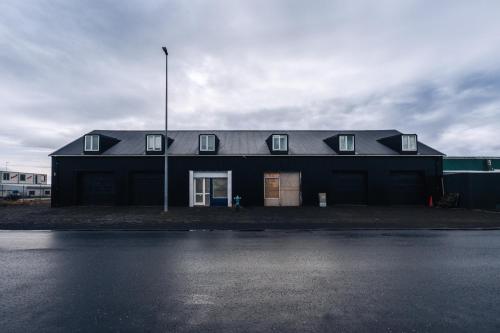 een zwart huis aan de kant van een straat bij Keflavik Cozy Apartments in Keflavík