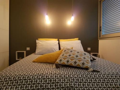 une chambre avec un lit avec deux oreillers dessus dans l'établissement Antilles YourHostHelper, à La Ciotat