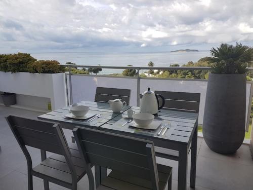 une table et des chaises sur un balcon avec vue sur l'océan dans l'établissement Antilles YourHostHelper, à La Ciotat