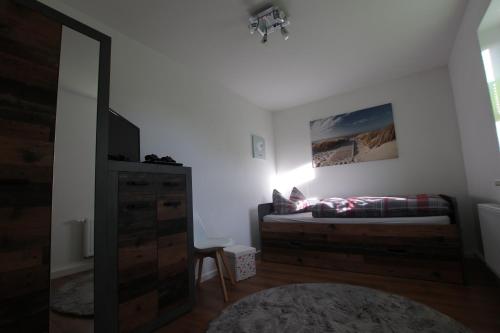 a bedroom with a bed and a dresser with a mirror at Ferienwohnung am Bärenstein in Bärenstein