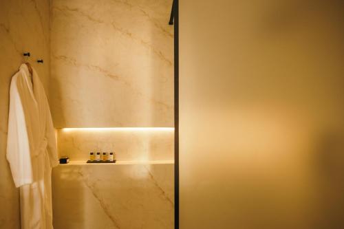 a bathroom with a shower with a tub at Pnoe Luxury Suites in Fira