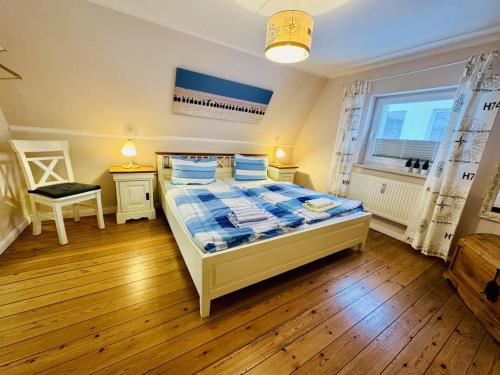 - une chambre dotée d'un lit avec des draps bleus et blancs dans l'établissement Moewennest, direkt am Alten Strom, à Warnemünde
