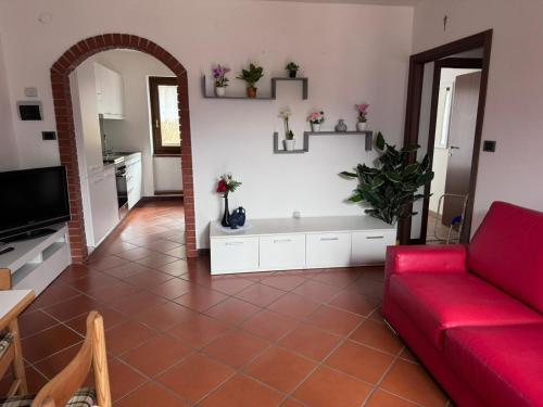 uma sala de estar com um sofá vermelho e piso em azulejo vermelho em Casa Stefy em Mezzolago