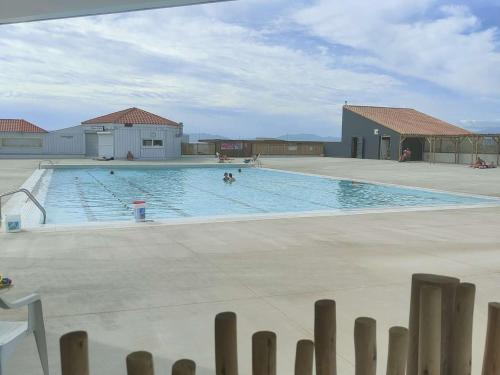une grande piscine avec des gens dans l'eau dans l'établissement Appartement T2 avec piscine, parking, animaux acceptés - Port Barcarès - FR-1-195-10, au Barcarès